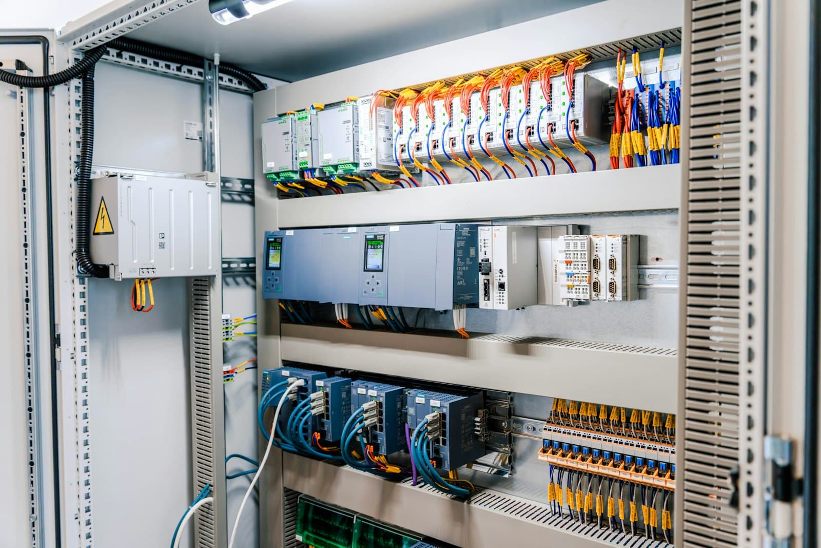 Quadro elettrico industriale aperto con moduli PLC e cablaggi